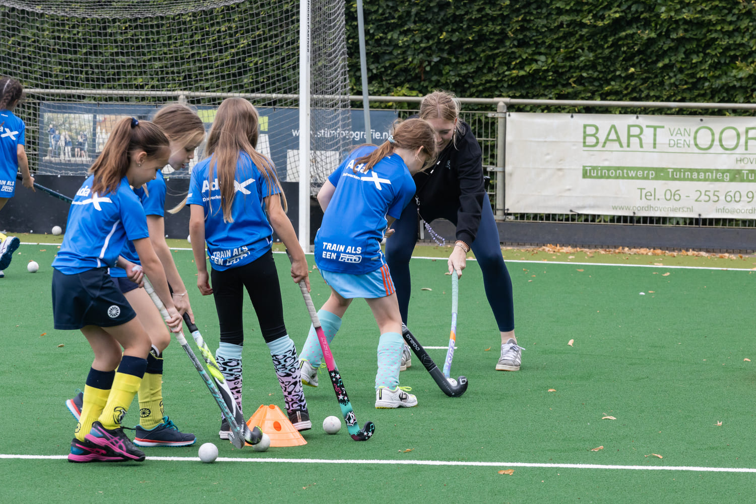 Kinderen krijgen hockeytraining tijdens ProHockey zomerkamp bij hockeyclub Prinsenbeek.
